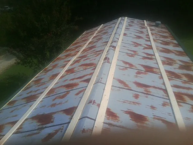 Rusted metal roof panels with new wood purlins before replacement — Storm Damage Roof Repair in Halstead by Roofing Brothers